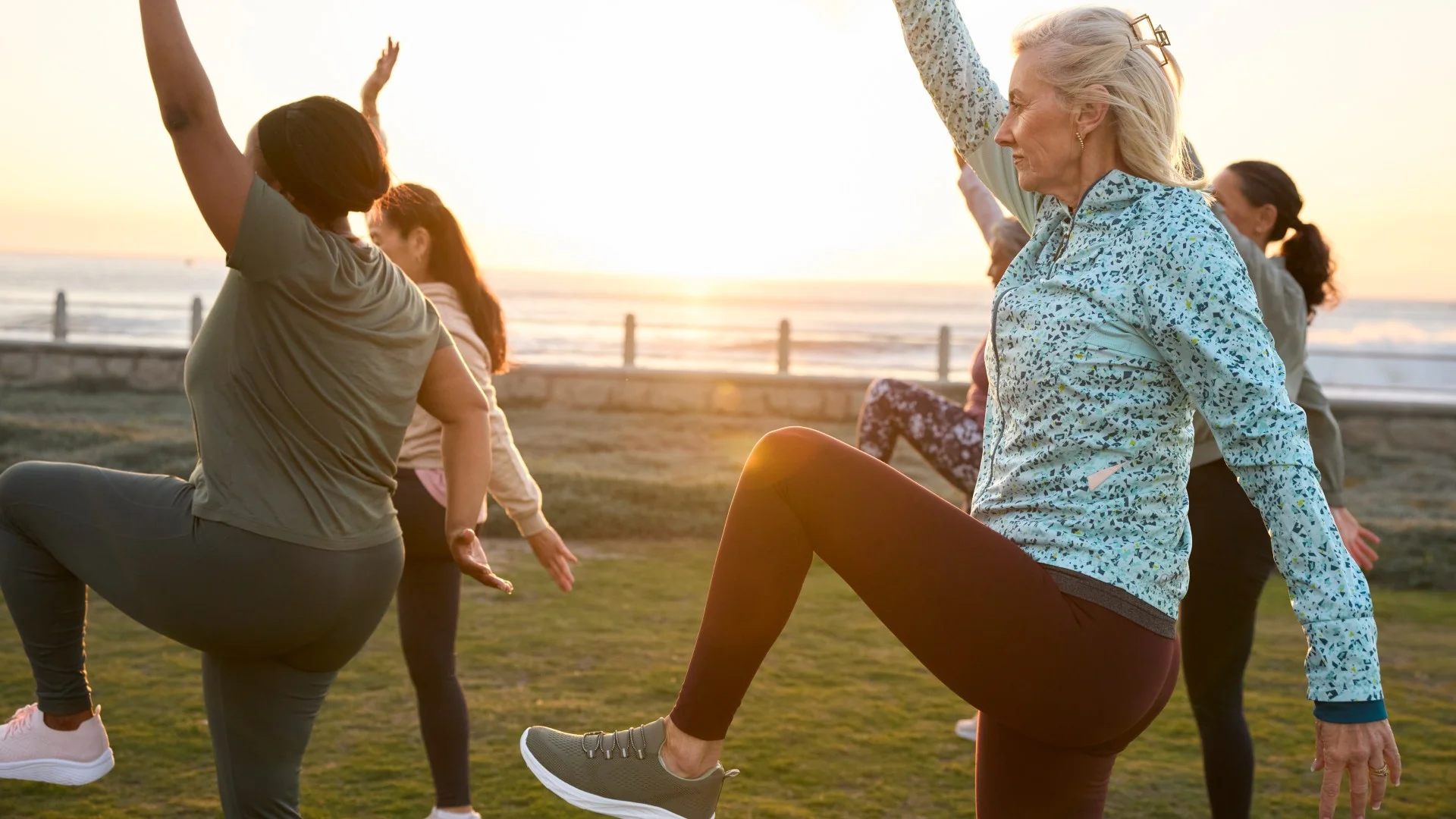 A group of mature exercisers balancing outside during a workout