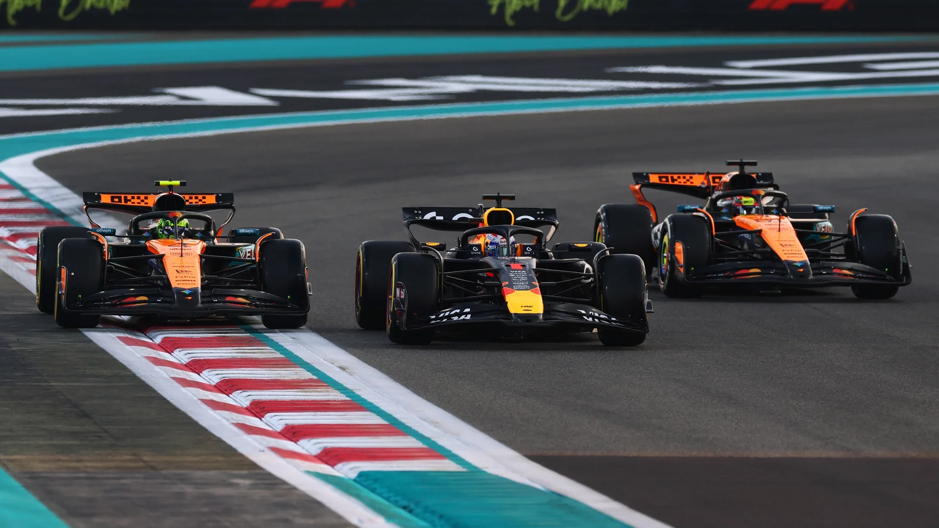 Max Verstappen of Red Bull Racing and Lando Norris and Oscar Piastri of McLaren in a row during a Formula 1 formation lap.